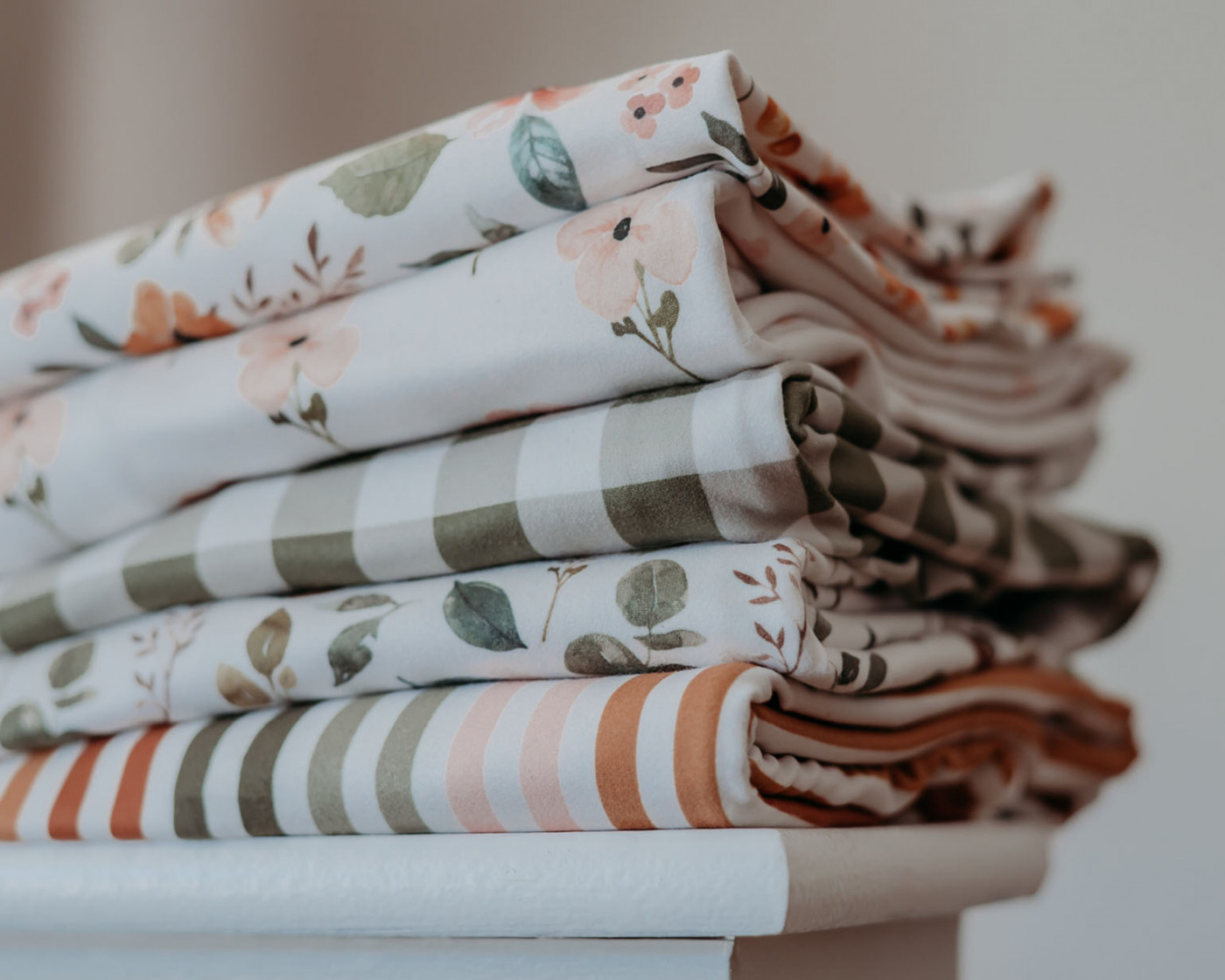 4 custom printed fabrics with holiday designs on them stacked together