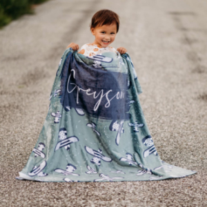 child holding personalized blanket